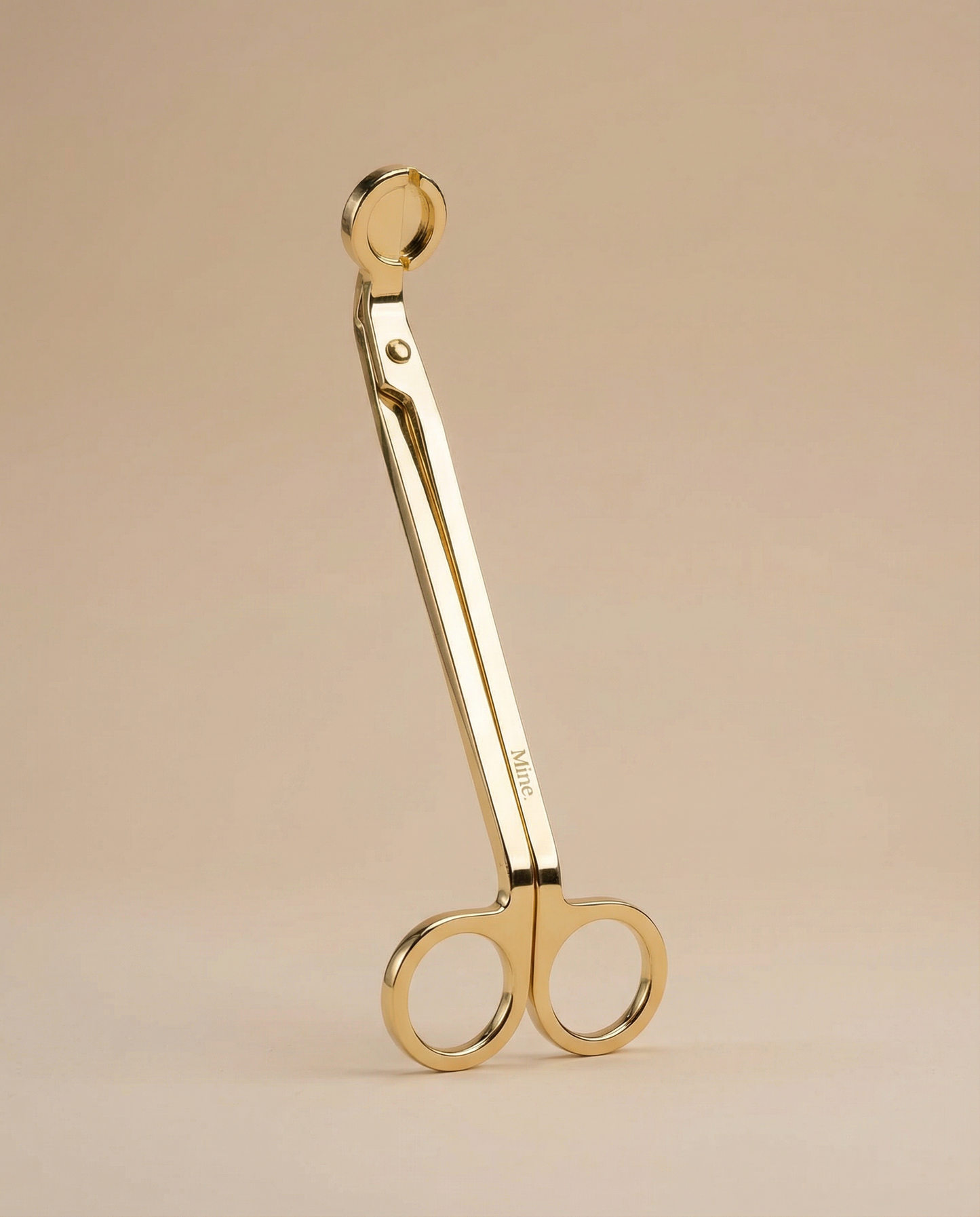 Gold scissors on a beige background