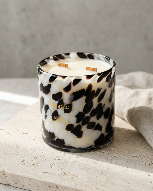 Candle with black and white pattern on a light surface