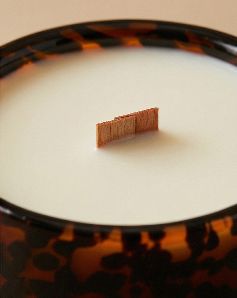 Close-up of a tortoiseshell-patterned candle with a small rectangular object on top.