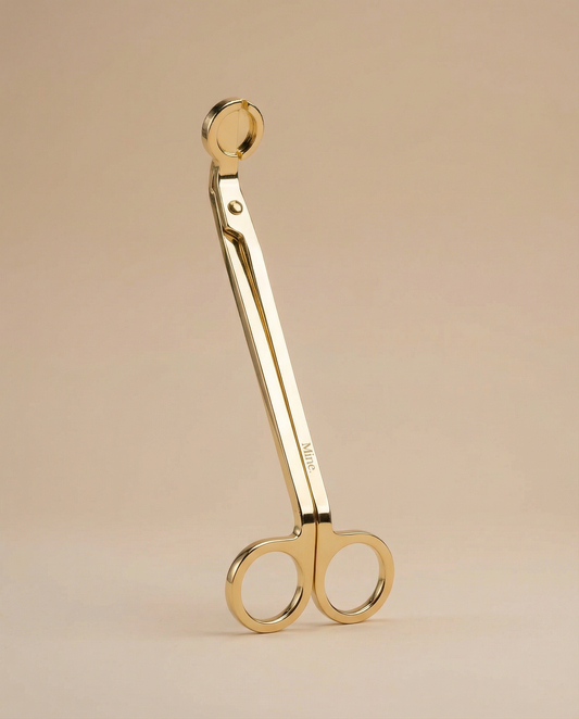 Gold scissors on a beige background