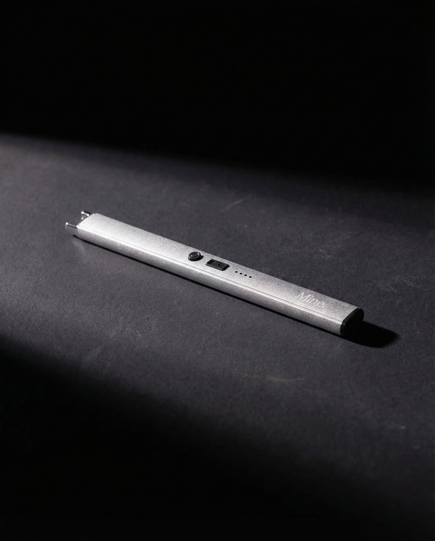 מצית חשמלי של Mine. בצבע כסוף על רקע כהה - נטען USB-C