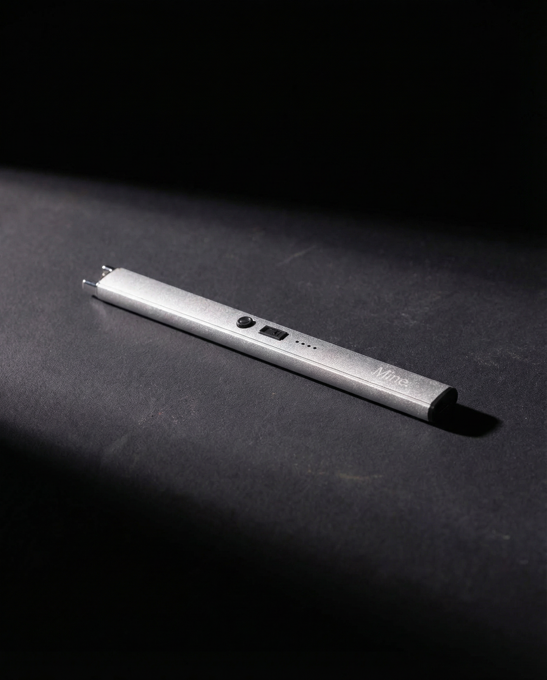 מצית חשמלי של Mine. בצבע כסוף על רקע כהה - נטען USB-C