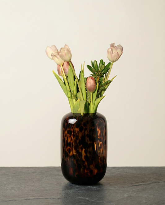 Tortoiseshell vase with pink tulips on a neutral background