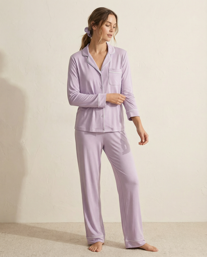 Woman wearing a lavender pajama set against a plain background