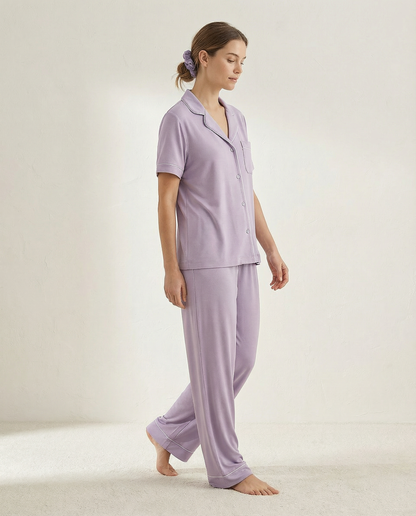 Woman wearing a lavender pajama set on a plain background