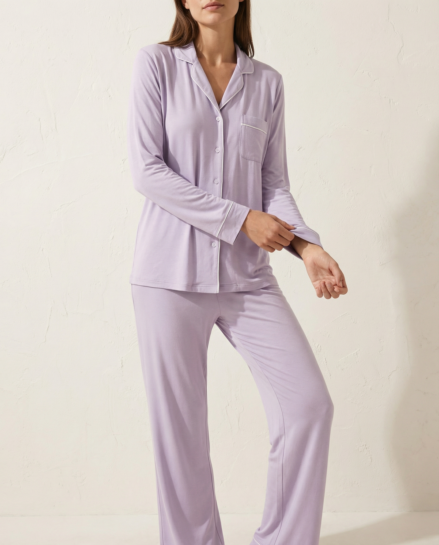 Woman wearing lavender pajamas against a plain background