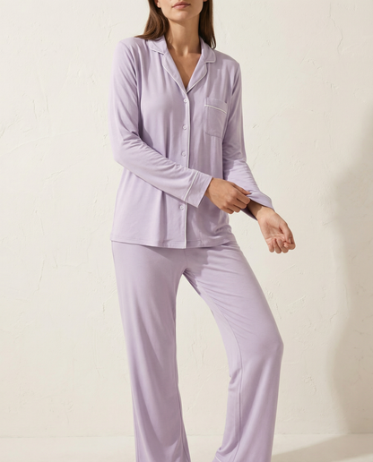 Woman wearing lavender pajamas against a plain background