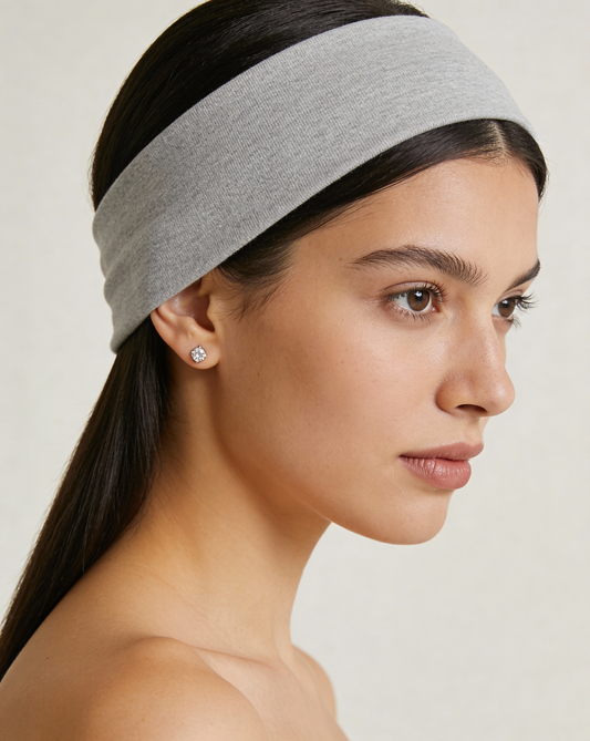Woman wearing a gray headband against a plain background