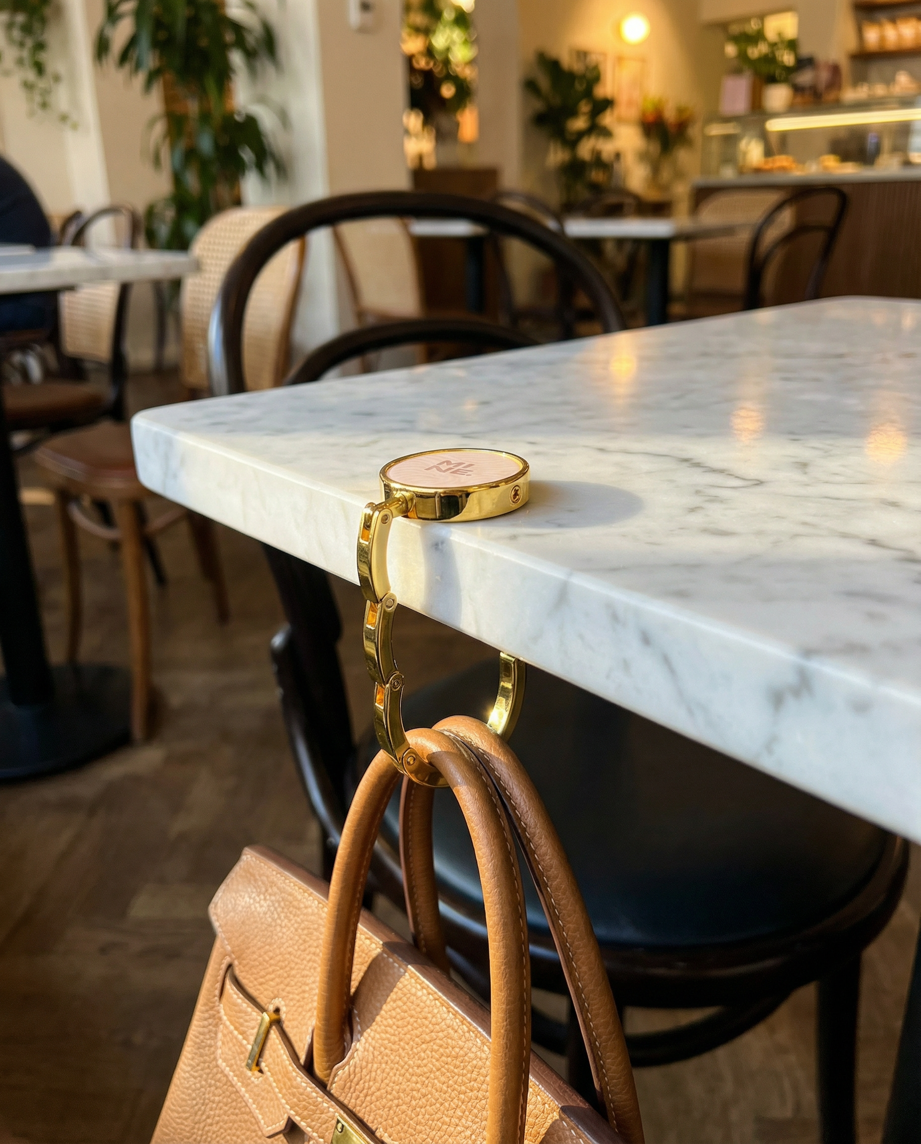 Marble table with gold cup holder and brown handbag in a cafe setting